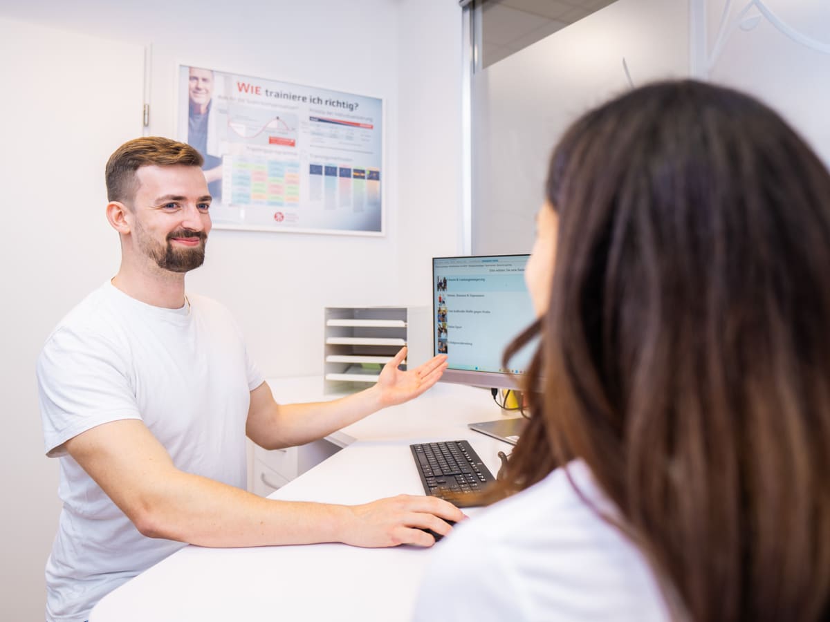 Therapeut erklärt einer Patientin ihre Auswertung am Bildschirm